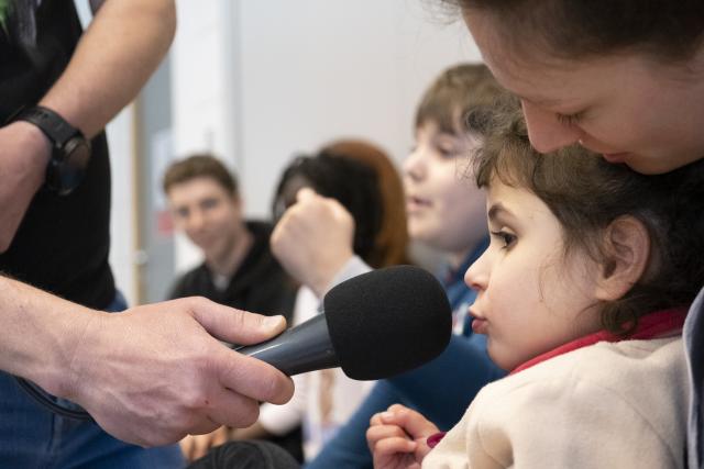 Une jeune fille parlant dans un micro placé devant sa bouche
