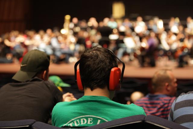 Un homme avec un casque sur les oreilles écoutant un concert