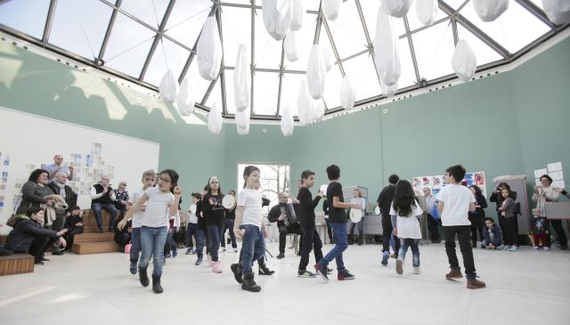 Des enfants se promenant dans une salle de musée avec un plafond transparent