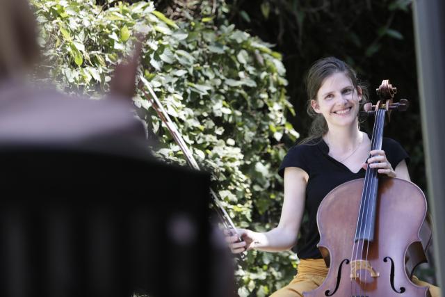 Une femme jouant du violoncelle et qui sourit