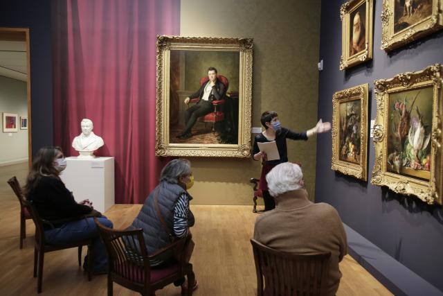 Une femme présentant des tableaux à des personnes assises devant