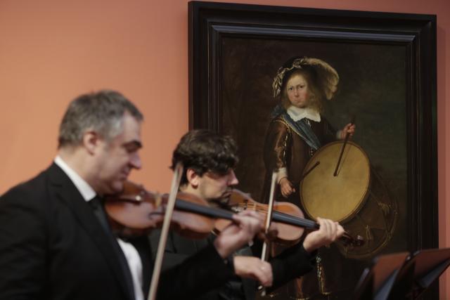 Deux violonistes jouant devant un tableau