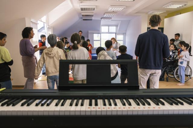 Un groupe d'enfants derrière un piano