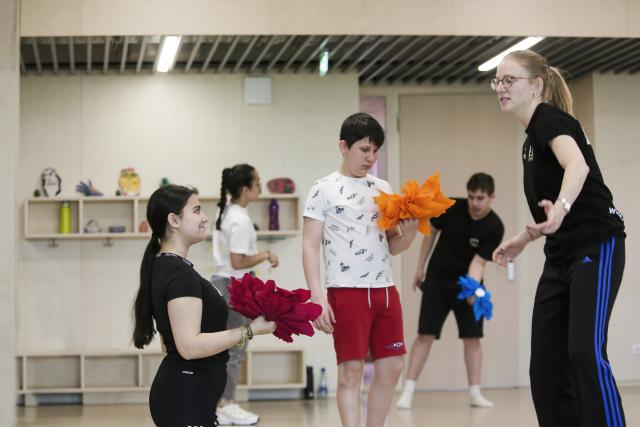 Des adolescents dansant ensemble avec des fleurs en papier