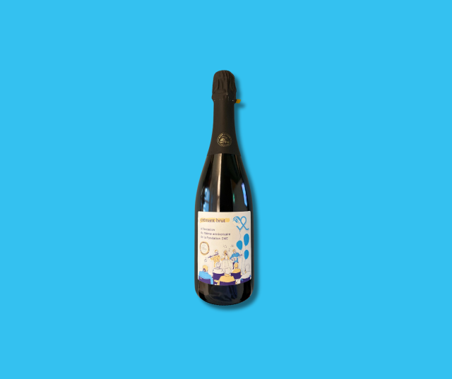 Bottle of EME sparkling wine on a blue background