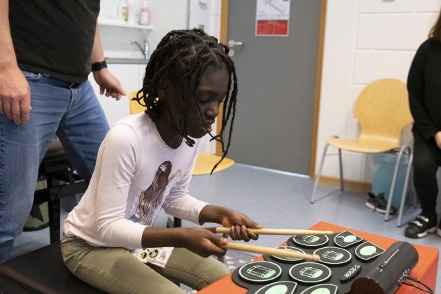 Une jeune fille jouant sur une batterie électrique