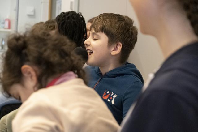 Des enfants assis côte à côte sur des chaises qui sourient