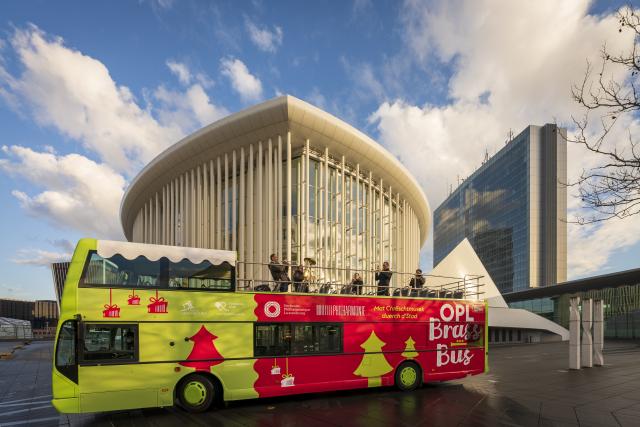 Des musiciens sur l'étage ouvert d'un bus devant la Philharmonie Luxembourg