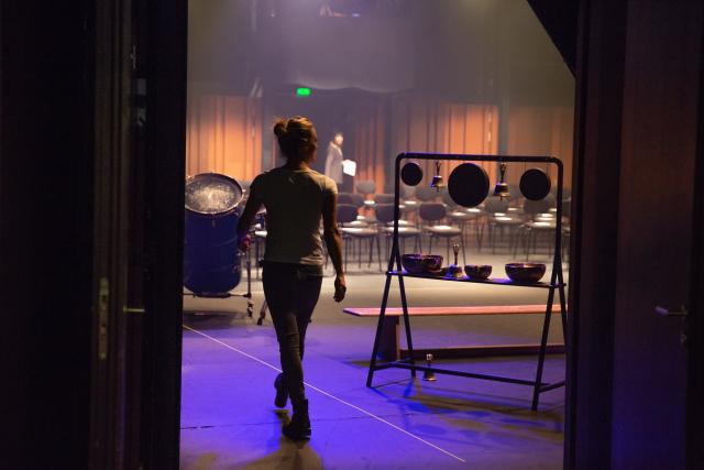 Une femme marchant sur scène à côté d'une installation musicale