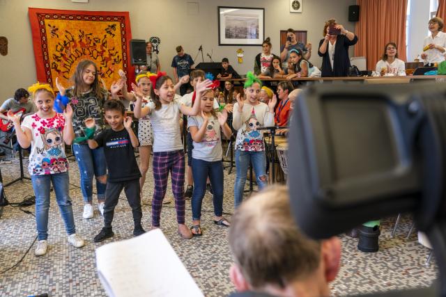 Des enfants dansant devant des personnes âgées