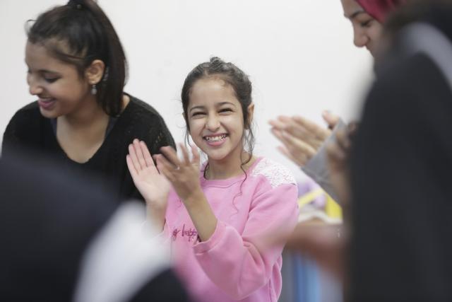 Des jeunes frappant dans leurs mains et souriant