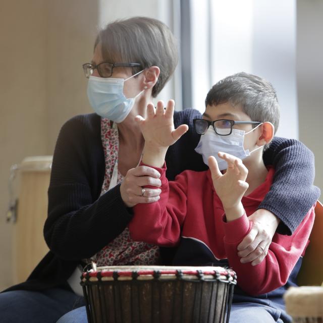 Une personne aidant un enfant à jouer du violon