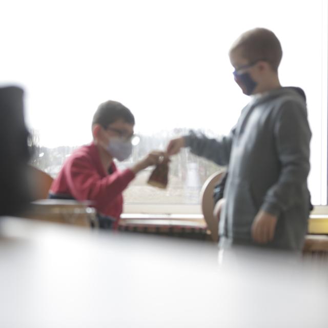 Un enfant donnant un cloche musicale à un autre enfant