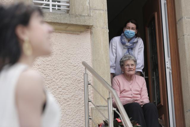 Une chanteuse et deux femmes sur les marches de leur escalier l'écoutant