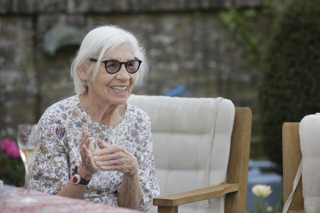 Une femme âgée assise et souriant