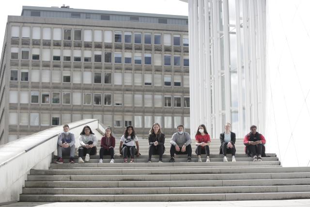 Des adolescents assis côte à côte sur les marches d'un escalier en extérieur