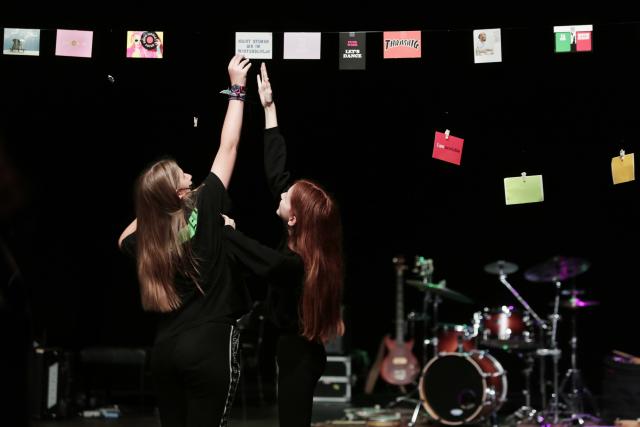 Deux adolescentes touchant des cartes suspendus au-dessus de la scène