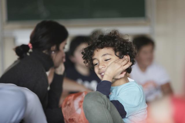 Des enfants assis au sol souriant