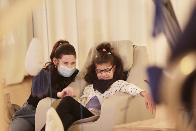 Deux personnes, dont l'une à besoins spécifiques, souriant