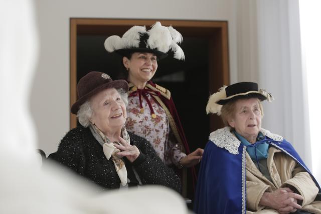 Deux personnes âgées avec des chapeaux souriant 