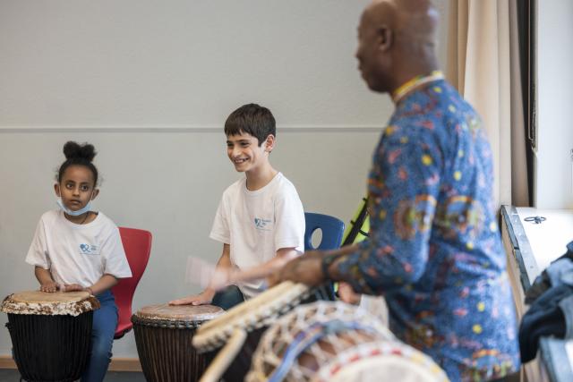 Un percussioniste et des enfants jouant du djémbé