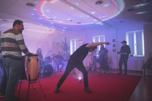 Des personnes jouant de la musique et un homme dansant au mileu
