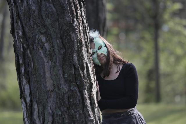 Une adolescente penchée contre un arbre