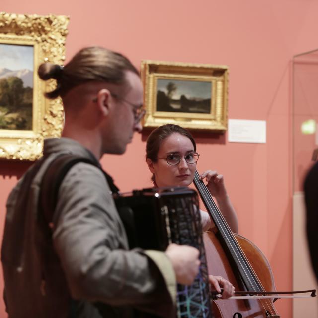 Un accordéoniste et une violoncelliste jouant dans un musée