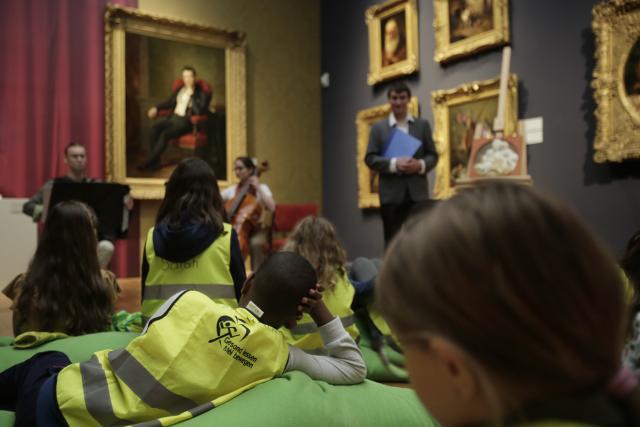 Des enfants écoutant des conteurs et des musiciens dans un musée