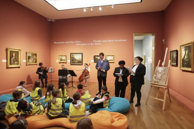 Des enfants écoutant des conteurs et des musiciens dans un musée