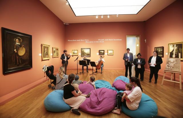 Des jeunes écoutant des conteurs et des musiciens dans un musée