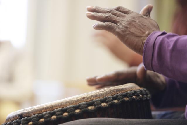 Des mains jouant du djembé