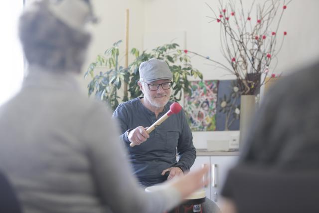 Jeannot Pirotte jouant des percussion avec un groupe de personnes