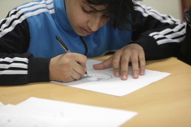 Un élève dessinant sur une feuille