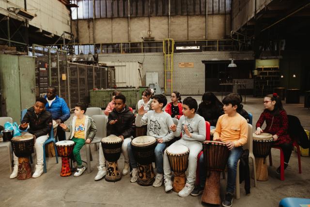 Un groupe d'enfants jouant du djembé ensemble