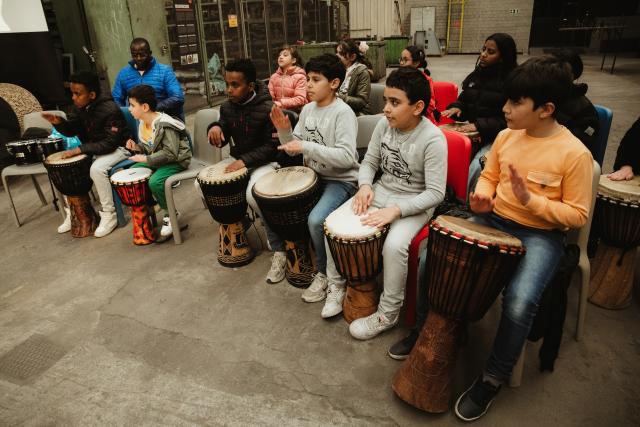 Un groupe d'enfants jouant du djembé ensemble