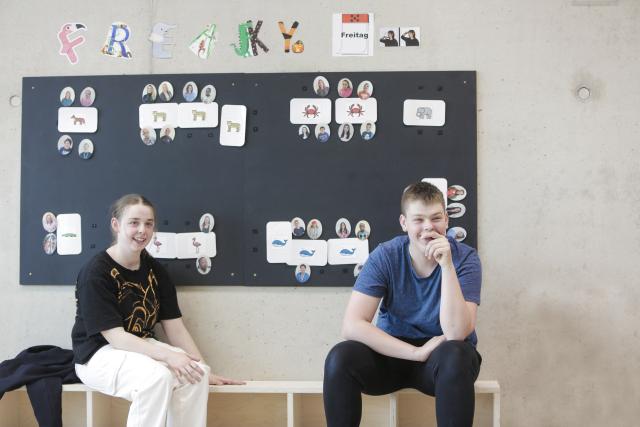 Deux adolescents assis sur un banc et souriant