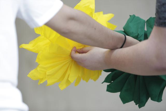 Deux personnes se tenant la main et tenant des fleurs en papier