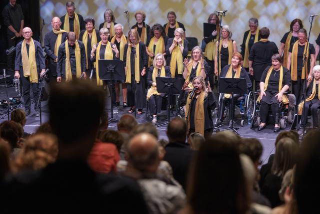 Un groupe de gospel portant une écharpe jaune sur scène