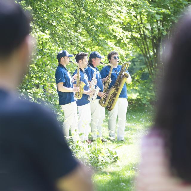 4 saxophonistes debout dans un jardin