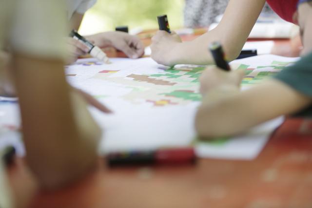 Des enfants coloriant une fresque