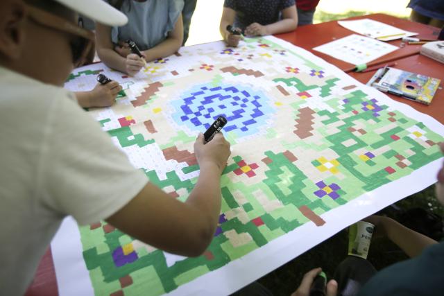 Des enfants coloriant une fresque