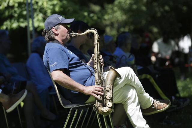 Un saxophoniste jouant assis dans un jardin