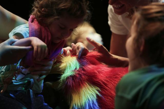 Un enfant entouré d'autres personnes avec une écharpe colorée autour du cou