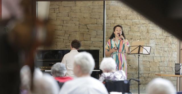 Un chanteuse et un pianiste jouant dans une maison de retraite