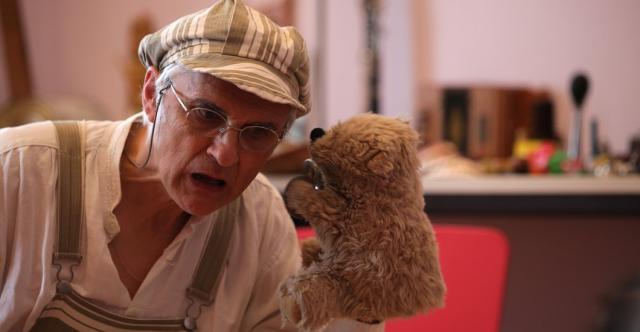 Un homme avec une marionette en forme d'ours