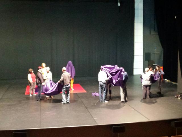 Des personnes dansant sur scène avec des voiles violets