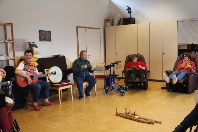 Des guitaristes chantant avec des personnes allongées dans des fauteuils