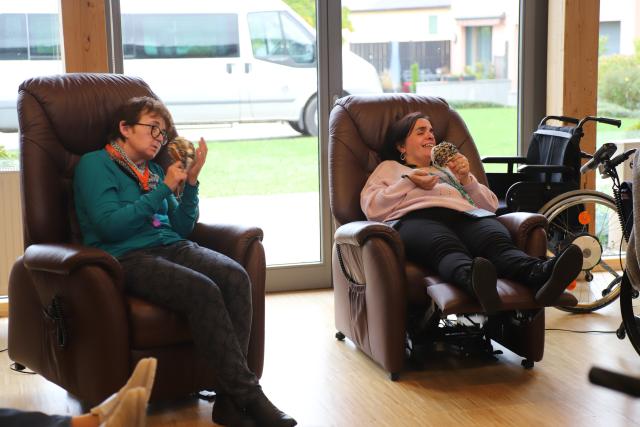 Des personnes allongées dans des fauteuils jouant des perscussions