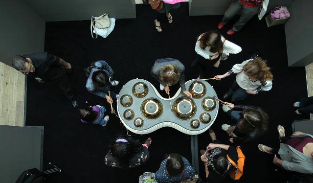 Un groupe de personnes rassemblées autour d'un instrument métallique